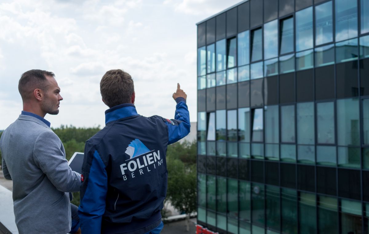 Folien-Berlin Mitarbeiter erklärt Kunde Möglichkeiten Gebäude Fenster