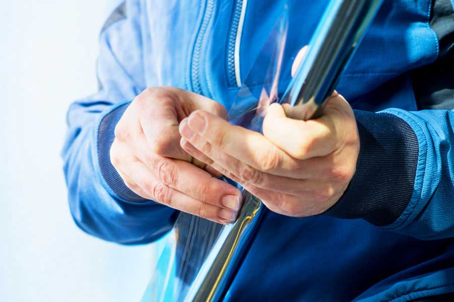 Mitarbeiter rollt UV-Schutzfolie ab