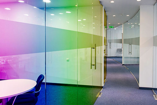 Farbige Fensterfolie an einer Glaswand im Büroflur