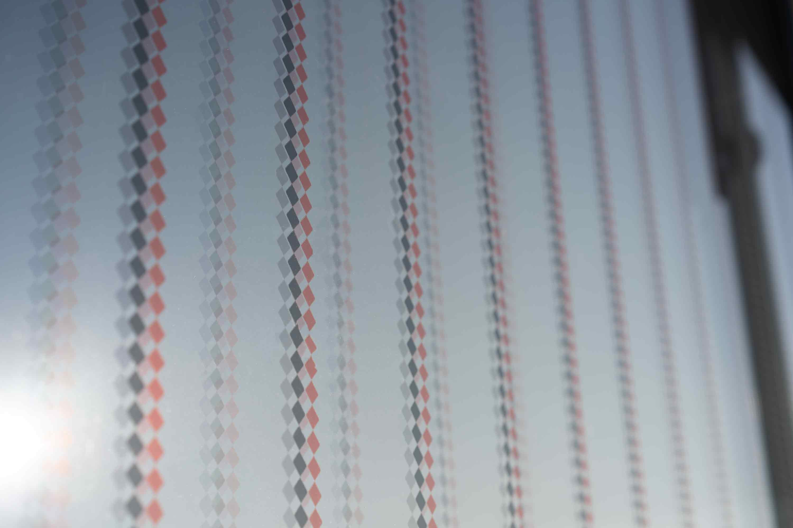 Nahaufnahme einer Vogelschutzfolie mit Rautenmuster in schwarz und rot